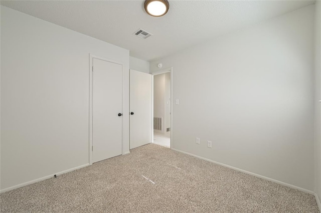 unfurnished bedroom featuring carpet floors and a textured ceiling