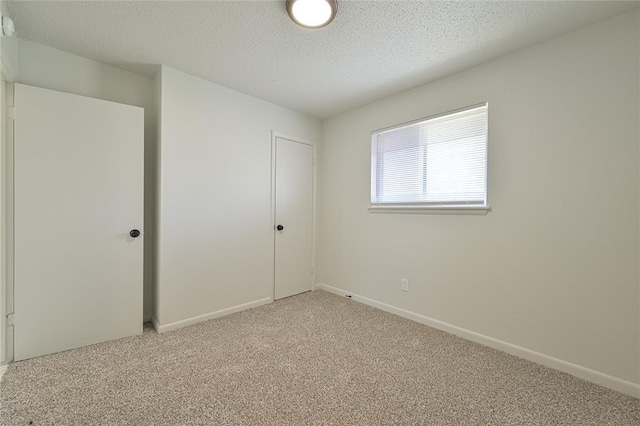 carpeted spare room featuring a textured ceiling