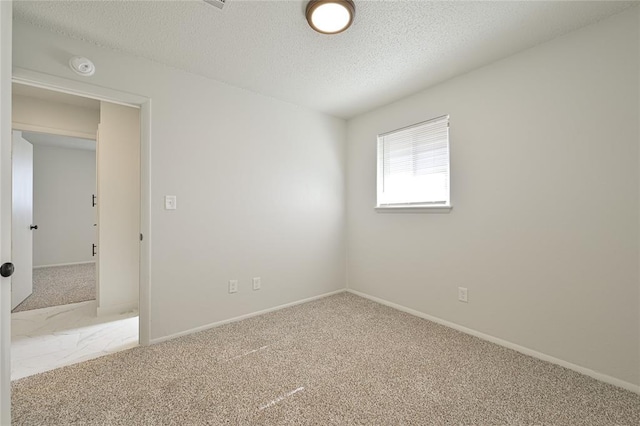 carpeted spare room featuring a textured ceiling