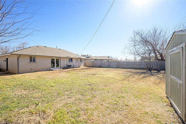 view of yard featuring central AC and a storage unit