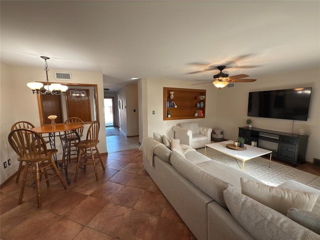 living room featuring ceiling fan with notable chandelier