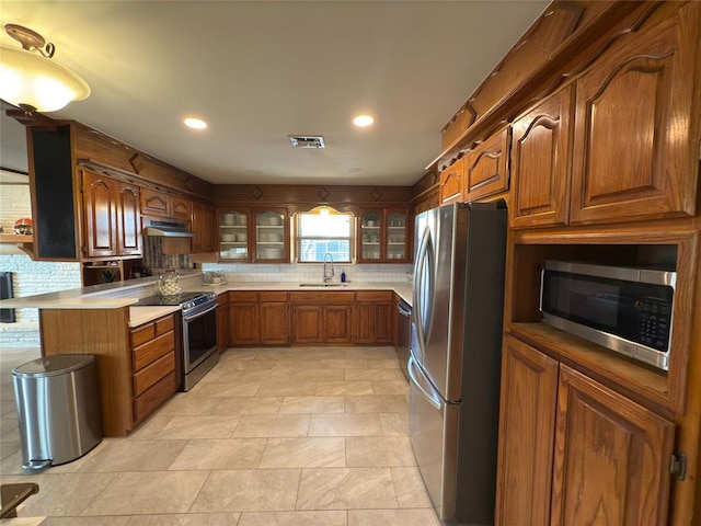 kitchen featuring appliances with stainless steel finishes, sink, and decorative backsplash