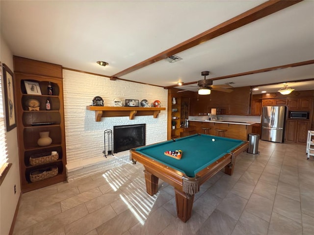 game room with ceiling fan, a large fireplace, pool table, and beam ceiling