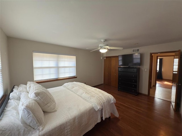 bedroom with dark wood-type flooring, a closet, and ceiling fan