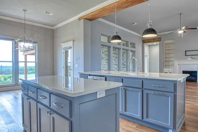 kitchen with sink, a center island with sink, and decorative light fixtures