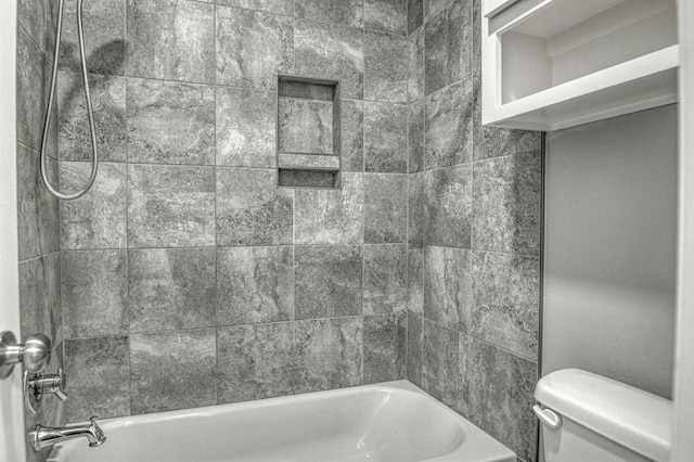 bathroom with tiled shower / bath and toilet