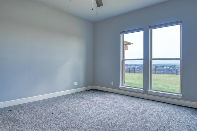 spare room with ceiling fan and carpet