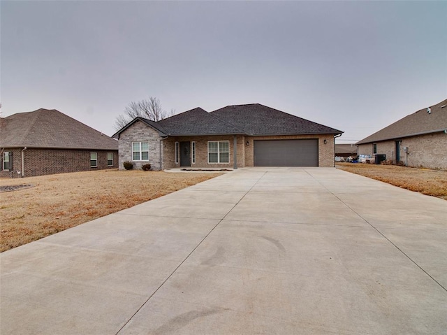 view of front of home featuring a garage and central air condition unit