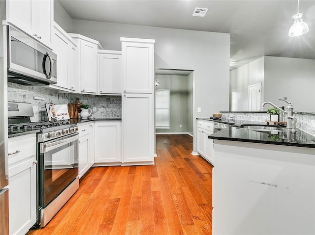 kitchen featuring white cabinetry, sink, pendant lighting, and stainless steel appliances