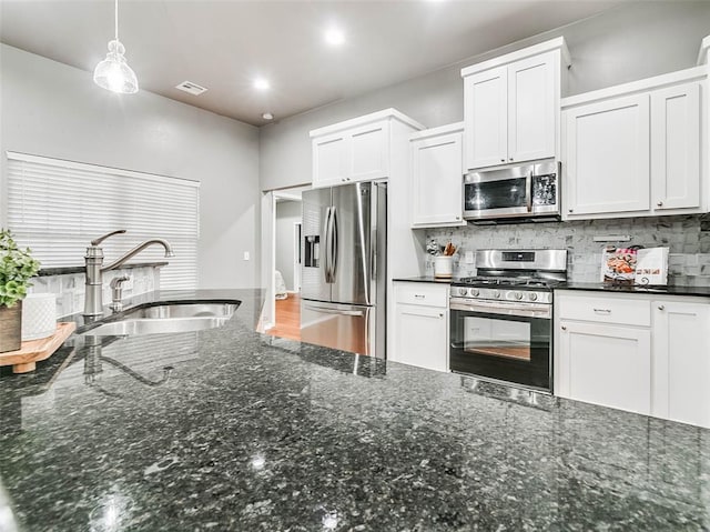 kitchen featuring sink, stainless steel appliances, hanging light fixtures, and white cabinets