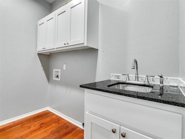 washroom featuring cabinets, wood-type flooring, sink, and washer hookup