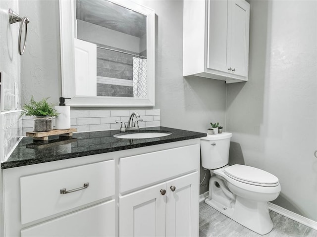 bathroom with vanity, backsplash, curtained shower, and toilet