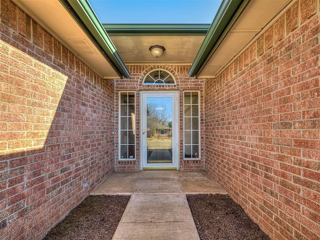 view of exterior entry with a patio