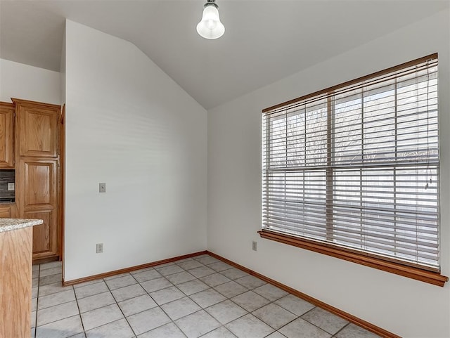 interior space with vaulted ceiling and light tile patterned flooring