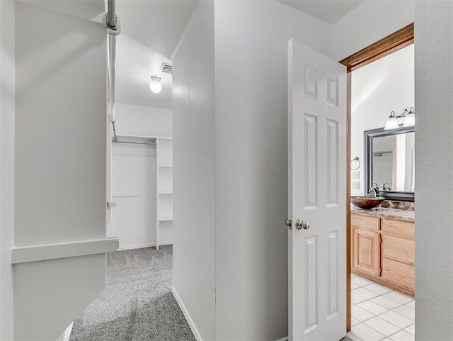 corridor featuring sink and light carpet