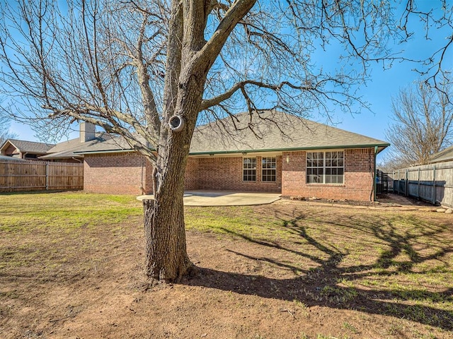 rear view of house with a yard and a patio area