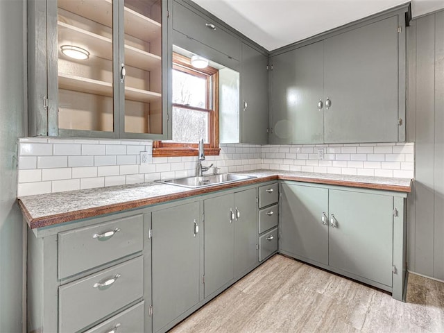 kitchen featuring gray cabinets, sink, and decorative backsplash