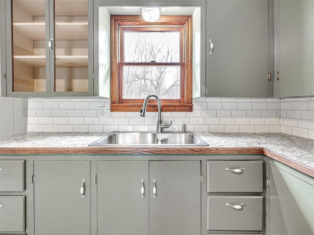 kitchen with gray cabinets, sink, and backsplash