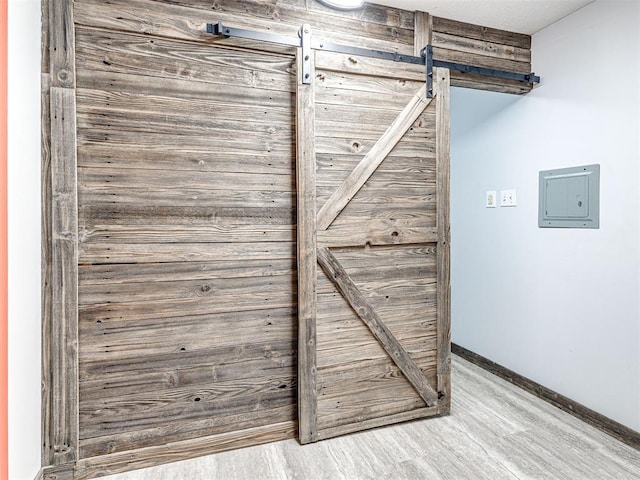 details featuring wood-type flooring, electric panel, and a barn door