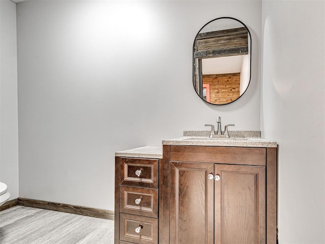 bathroom featuring hardwood / wood-style flooring, vanity, and toilet