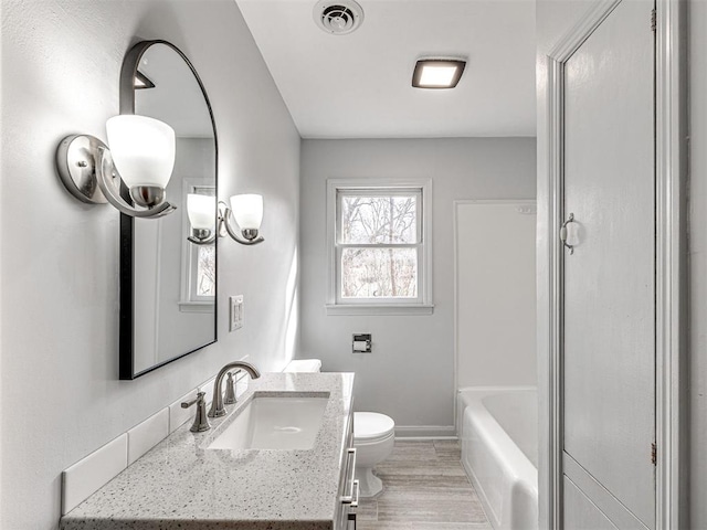 bathroom with hardwood / wood-style flooring, vanity, and toilet