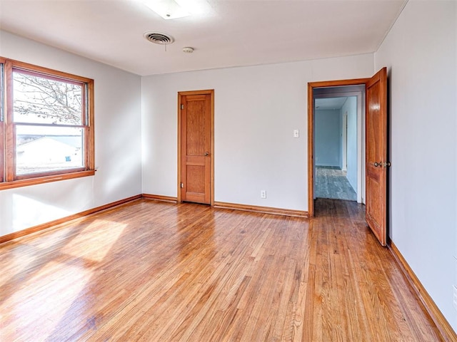 unfurnished room with light wood-type flooring