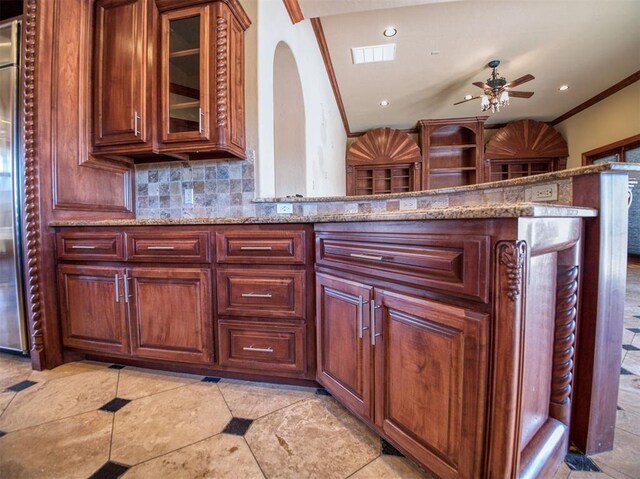 7 Country Club Rd, Shawnee, OK 74801 - kitchen featuring crown molding, kitchen peninsula, ceiling fan, light stone countertops, and decorative backsplash