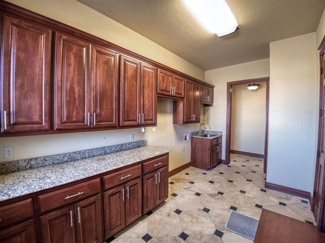 7 Country Club Rd, Shawnee, OK 74801 - kitchen featuring light stone counters, sink, and a textured ceiling