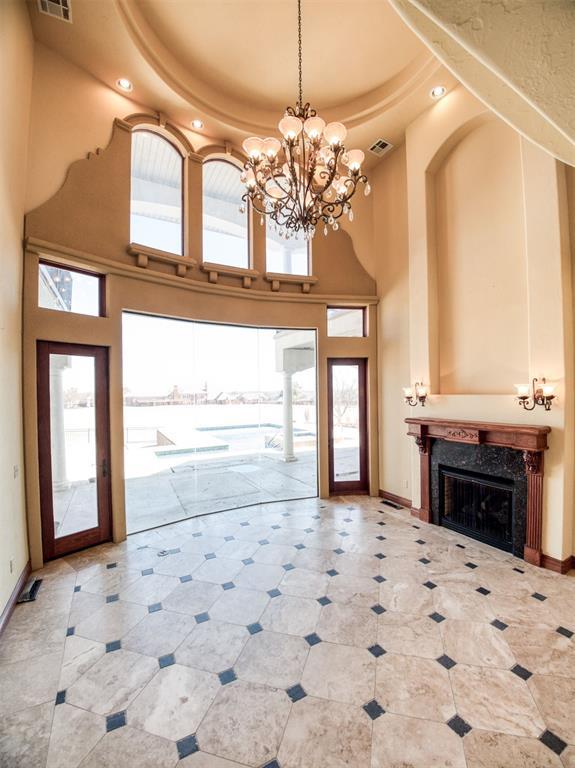 7 Country Club Rd, Shawnee, OK 74801 - unfurnished living room with a towering ceiling, a high end fireplace, and a raised ceiling