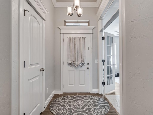 entryway with a notable chandelier and crown molding