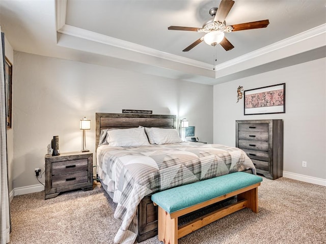 carpeted bedroom with ornamental molding and a tray ceiling