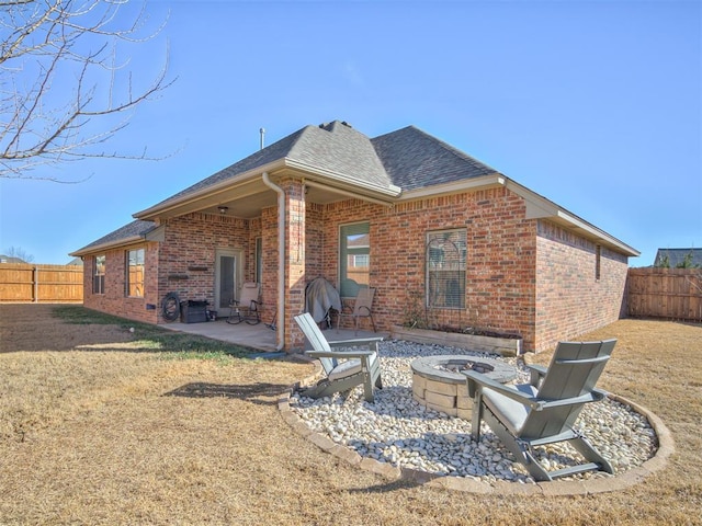 back of house featuring a patio, a fire pit, and a lawn