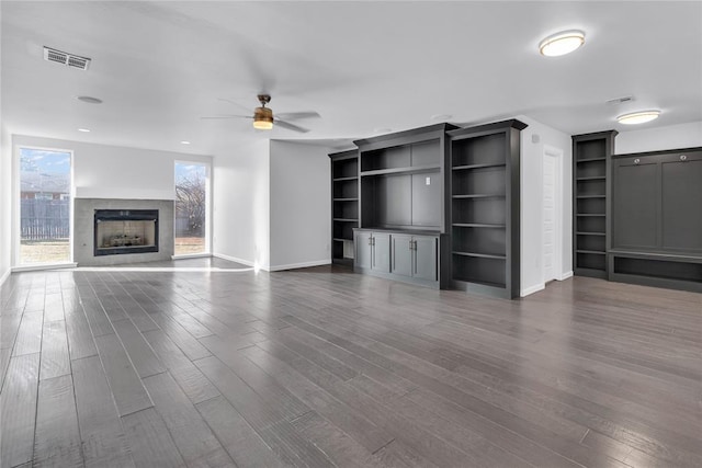 unfurnished living room featuring dark hardwood / wood-style floors and ceiling fan