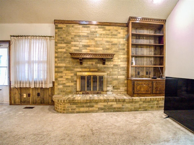 carpeted living room featuring a fireplace and a textured ceiling