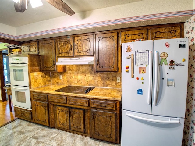 kitchen with tasteful backsplash, white appliances, and ceiling fan