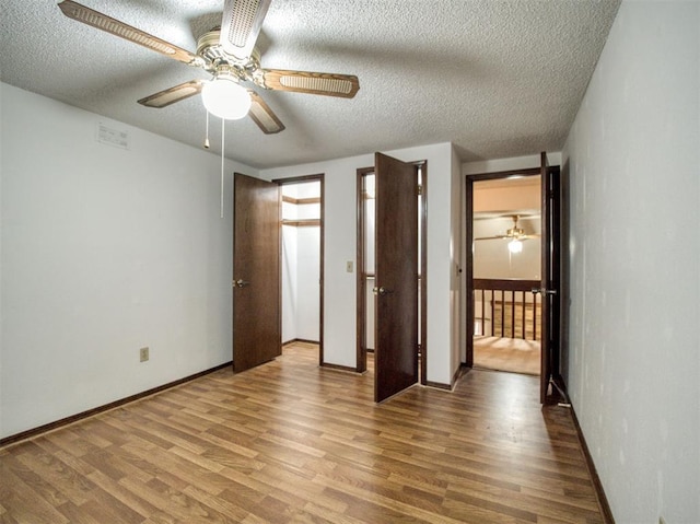 unfurnished bedroom with ceiling fan, hardwood / wood-style floors, and a textured ceiling