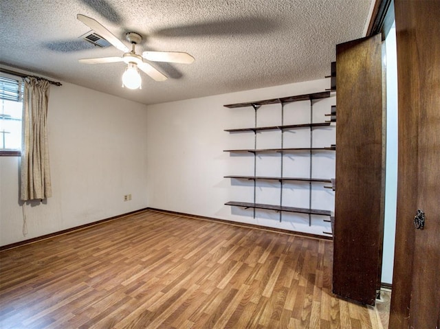 unfurnished room featuring hardwood / wood-style flooring, a textured ceiling, and ceiling fan