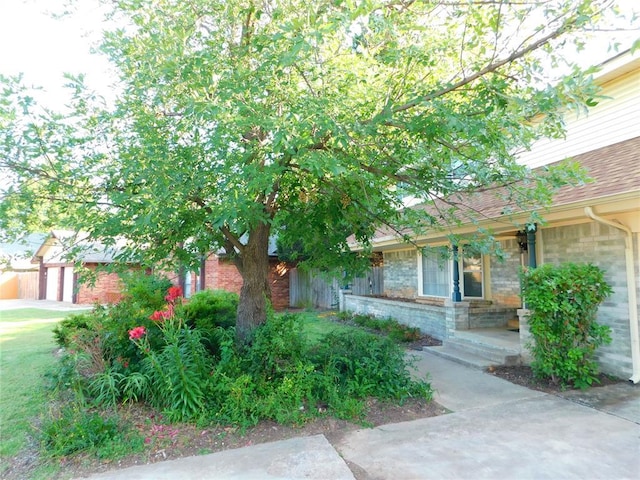 7318 Hummingbird Cir, Oklahoma City, OK 73162 - obstructed view of property featuring brick siding, a garage, and roof with shingles
