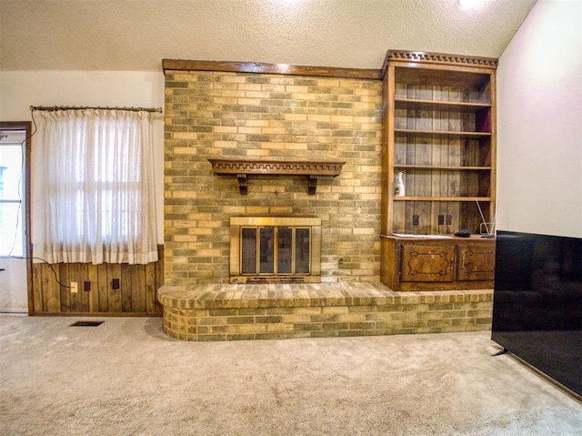 7318 Hummingbird Cir, Oklahoma City, OK 73162 - unfurnished living room featuring carpet flooring, a brick fireplace, and a textured ceiling