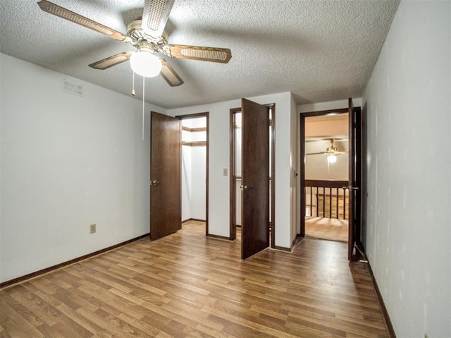 7318 Hummingbird Cir, Oklahoma City, OK 73162 - unfurnished bedroom featuring wood finished floors, a textured ceiling, and a ceiling fan