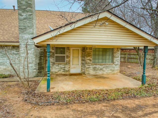7318 Hummingbird Cir, Oklahoma City, OK 73162 - view of front facade featuring a chimney, roof with shingles, and a patio area