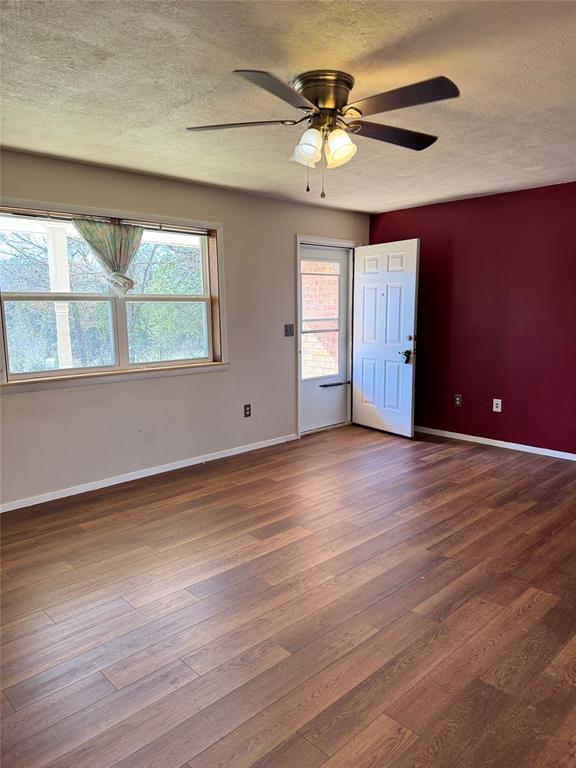 spare room featuring hardwood / wood-style flooring, plenty of natural light, and a textured ceiling