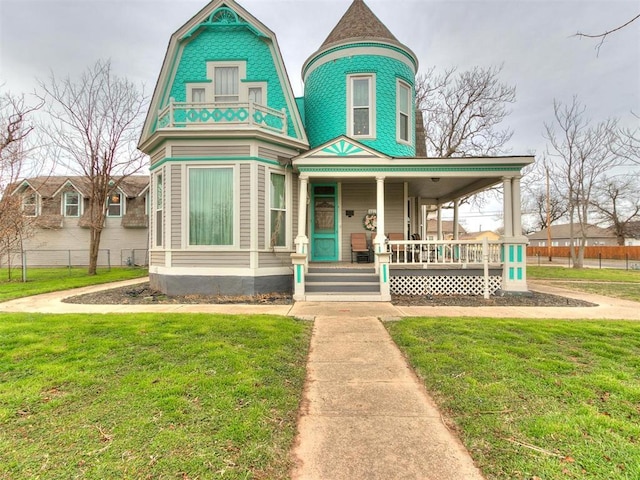 victorian-style house featuring a porch and a front lawn