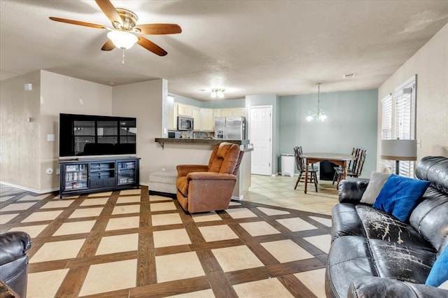 living room with ceiling fan with notable chandelier