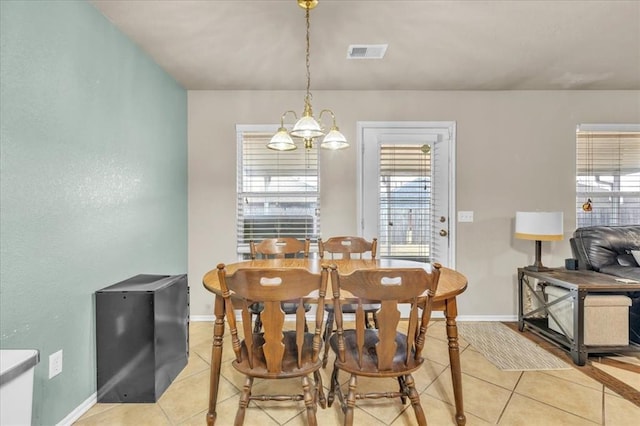 tiled dining space featuring an inviting chandelier