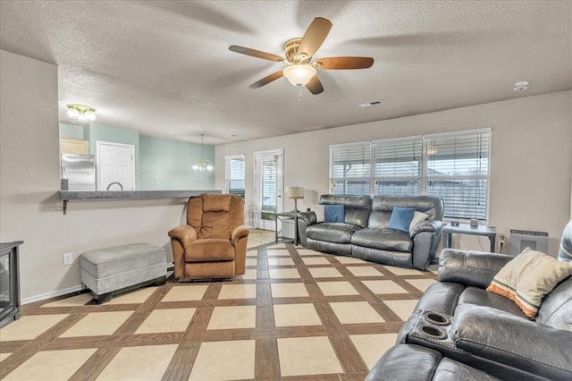 living room with ceiling fan and a textured ceiling