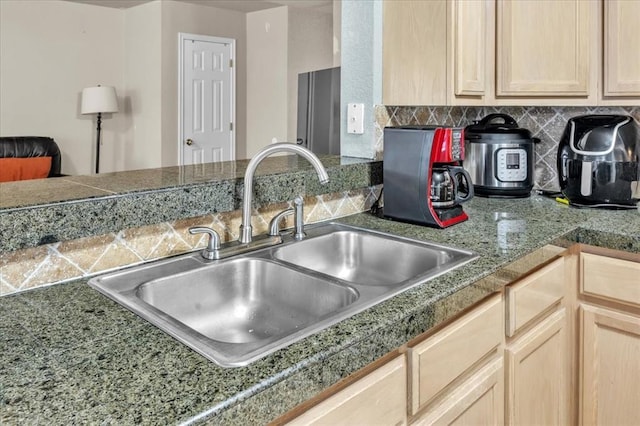 kitchen with tasteful backsplash, sink, and light brown cabinets