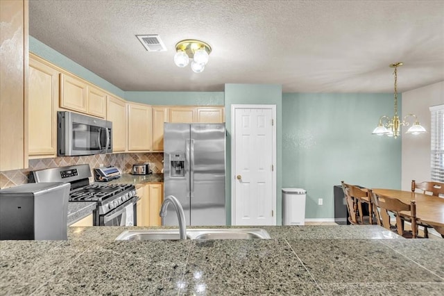 kitchen with appliances with stainless steel finishes, sink, decorative backsplash, and light brown cabinets