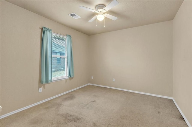 spare room featuring ceiling fan and light carpet