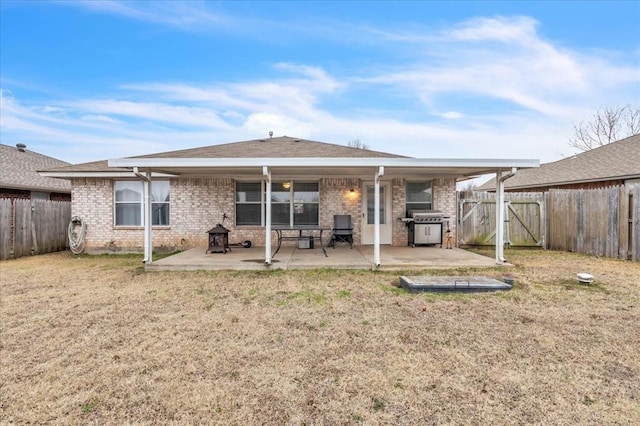 rear view of house with a patio and a lawn